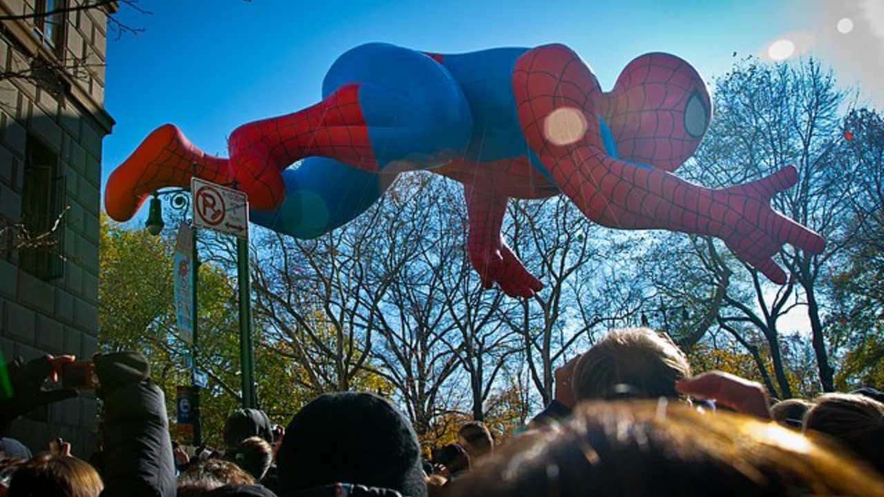 a giant spider - man balloon floats in the air during the macy's thanksgiving day parade in new york city