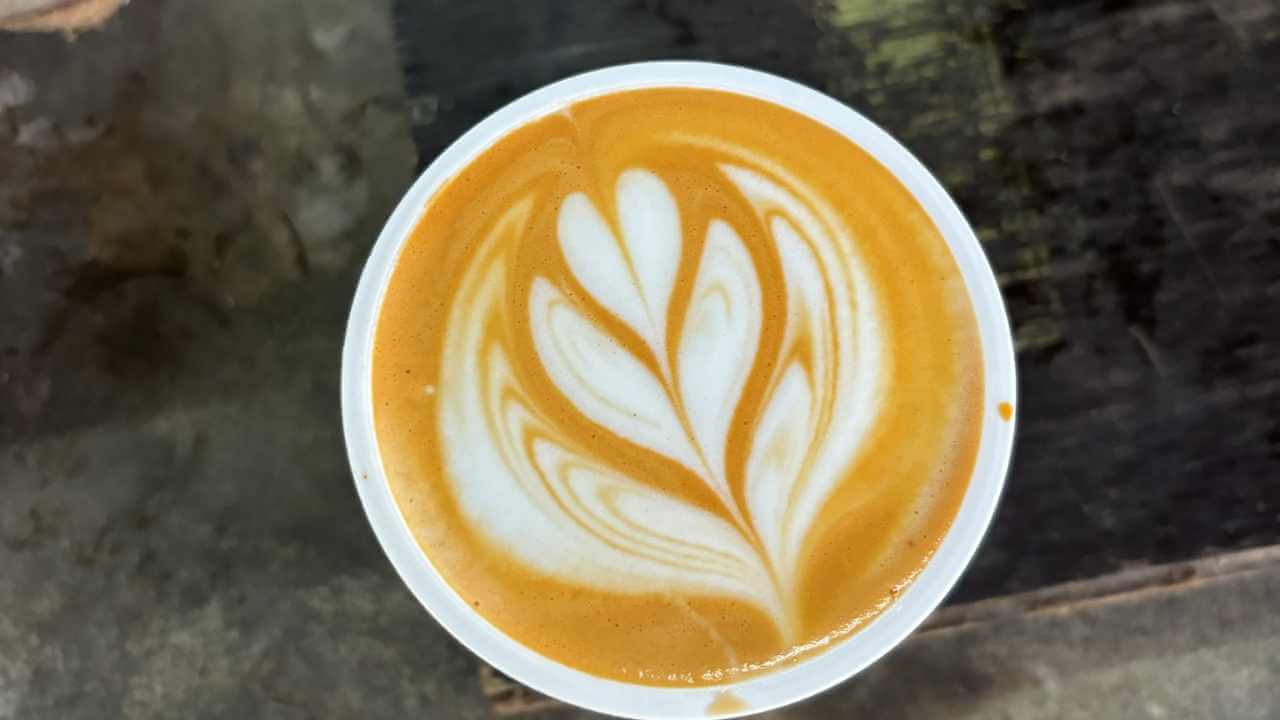 a cup of coffee sitting on top of a wooden table