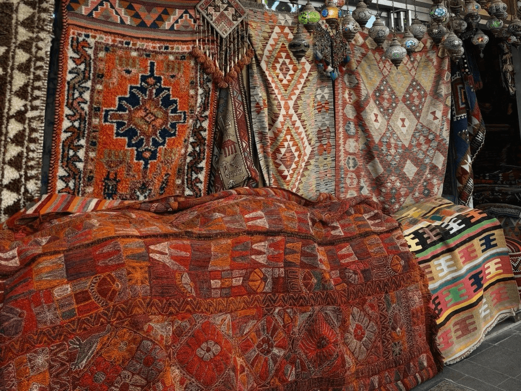 colorful rugs and tapestries hanging up in a market in turkey