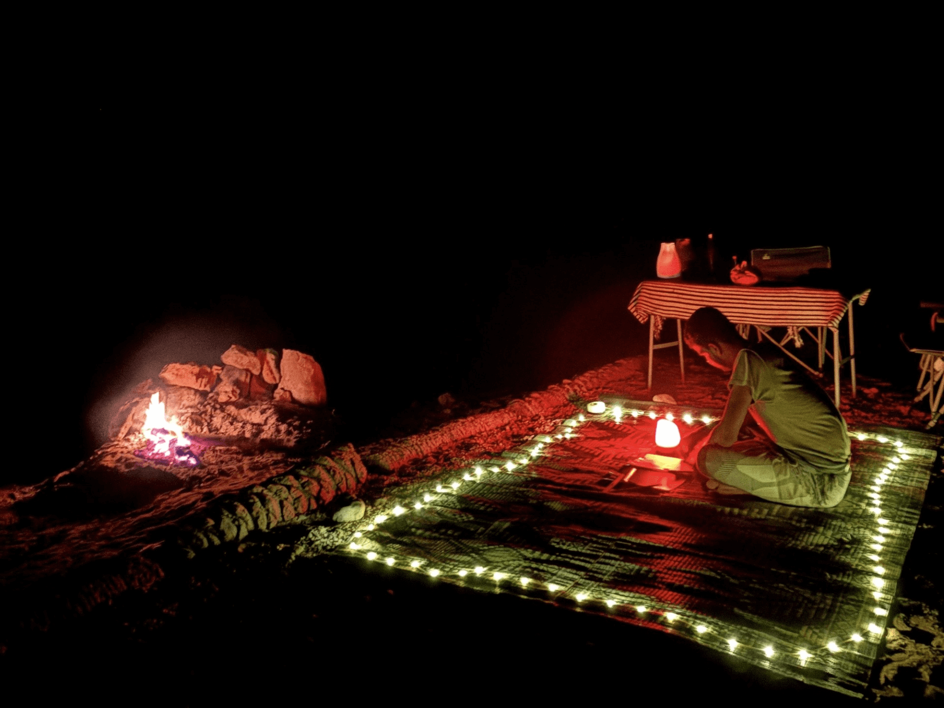 person sitting on the ground with candles around them