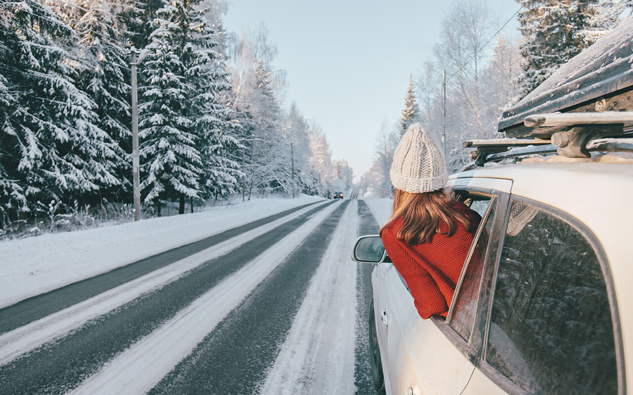 Magic car trip on the road by winter forest covered by snow