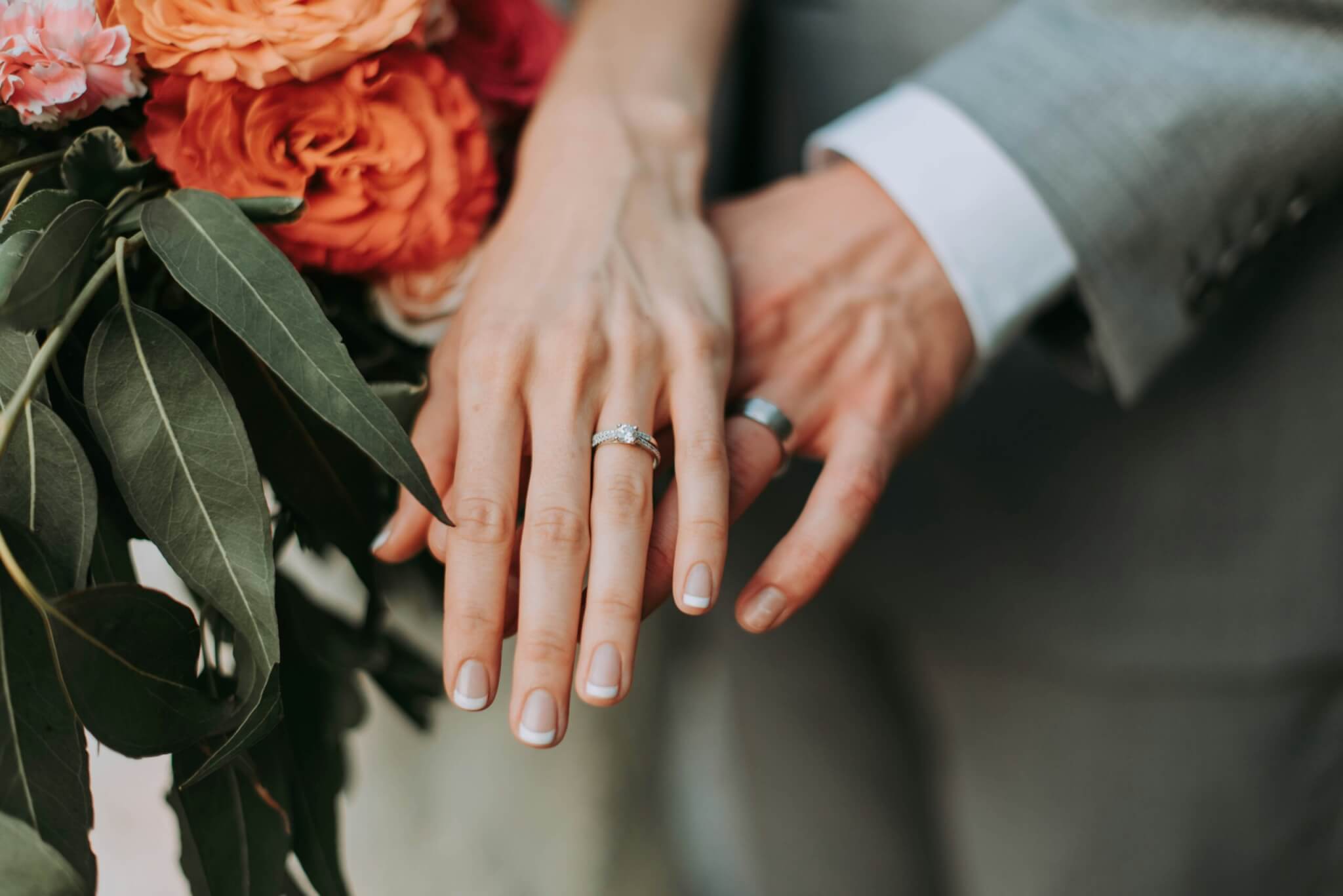 bride and groom showing off their wedding rings