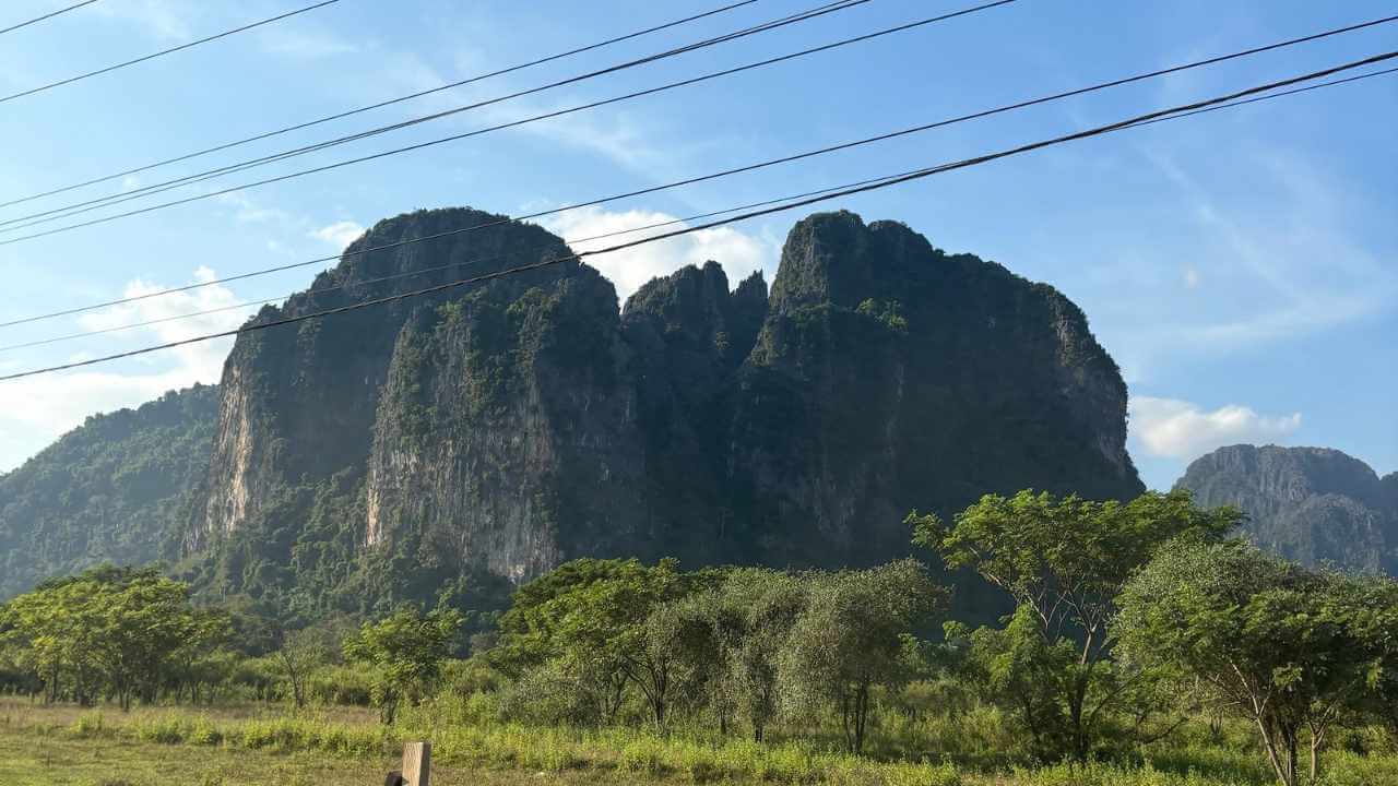 a view of a mountain range from the side of the road