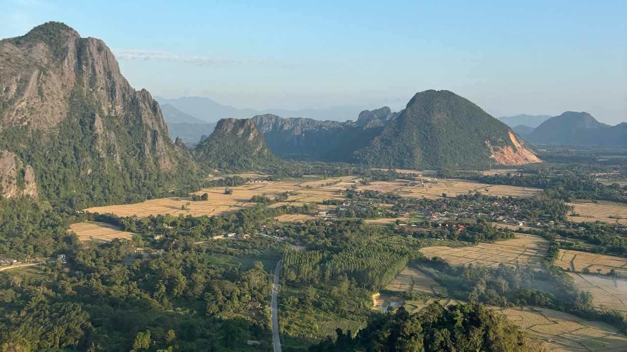 an aerial view of a valley with mountains in the background