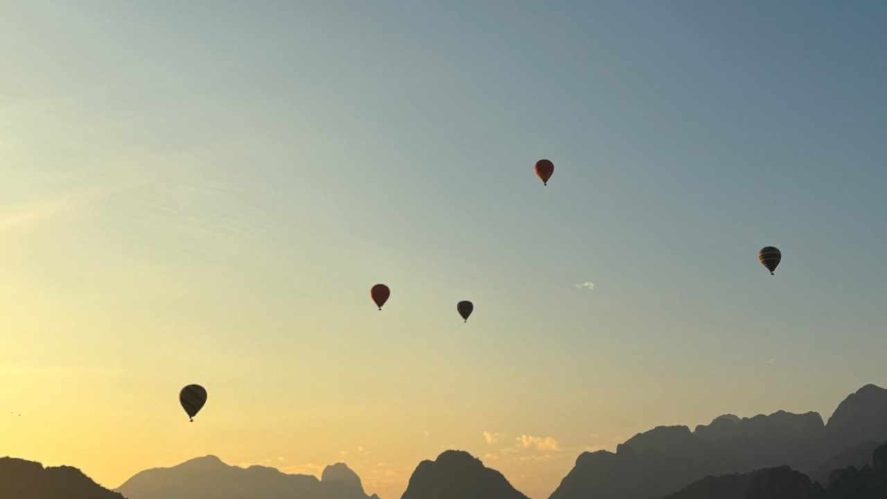many hot air balloons are flying in the sky
