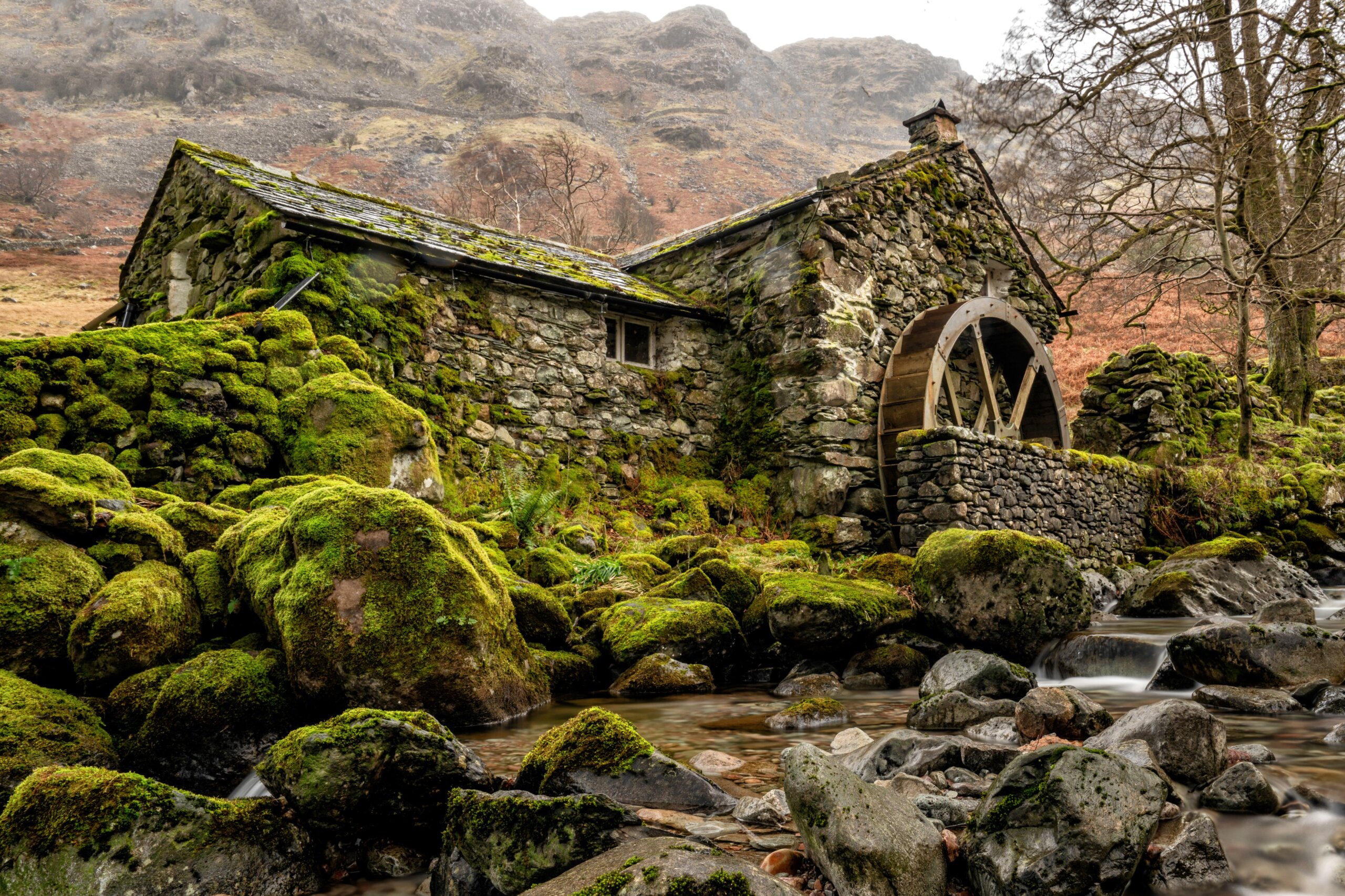 Borrowdale Mill in the winter in the Lake District National Park England. Green moss on the rocks surrounding the old watermill near Keswick and Buttermere