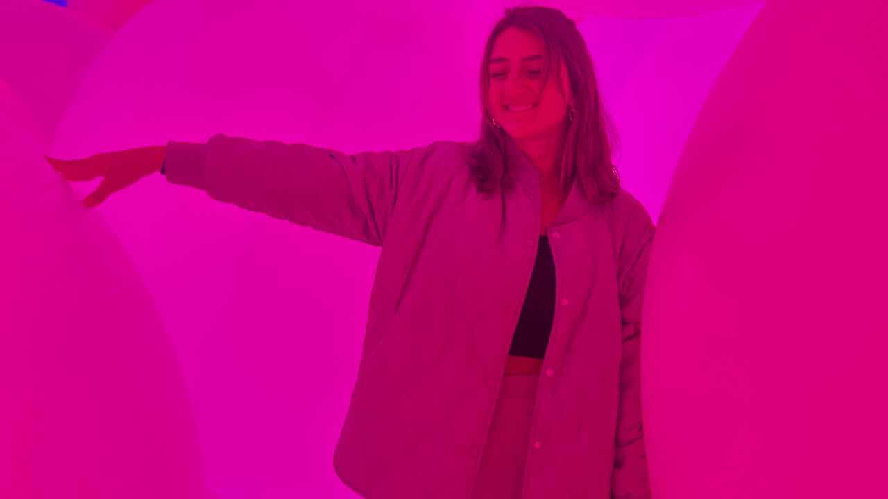 a person is standing in front of a pink light