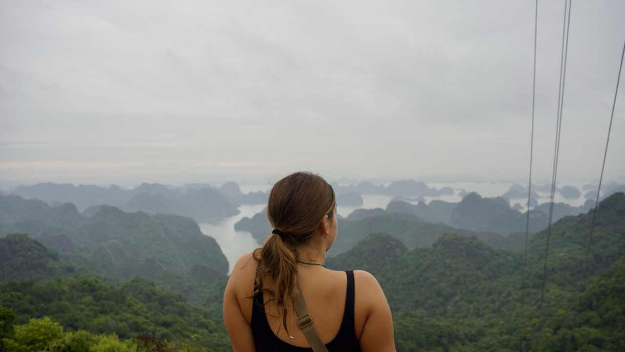 a person looking out over the ocean from the top of a cable car