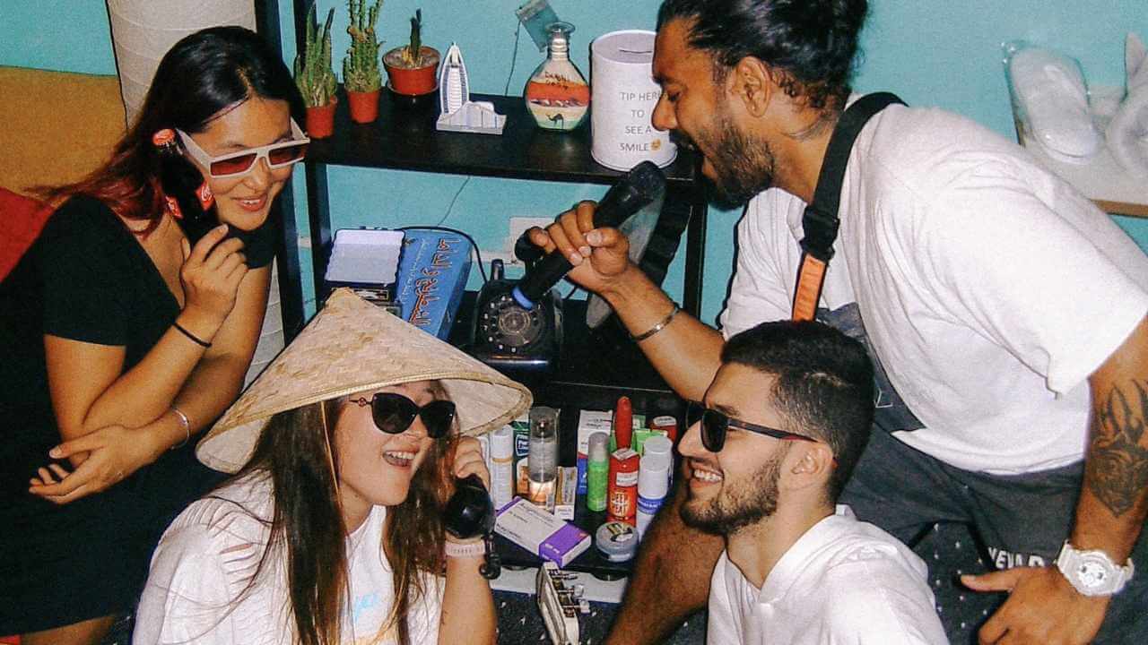 a group of people sitting around a table talking on cell phones