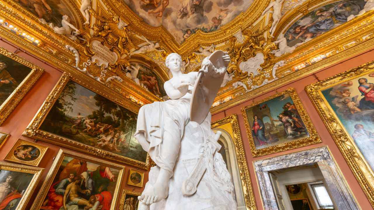 Ornate art museum interior with classical sculpture and framed paintings