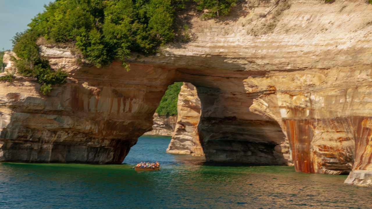 a boat is in the water near a large rock formation