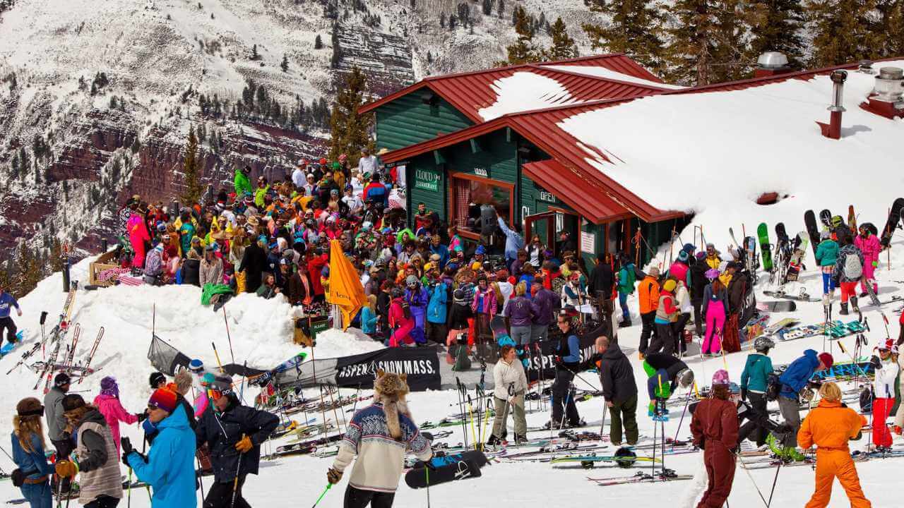 a large crowd of skiers and snowboarders at the top of a mountain