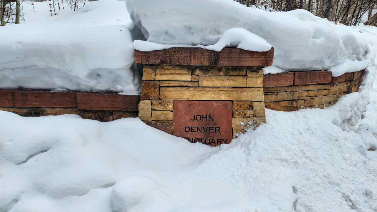 a sign that says no parking on the side of the road in the snow