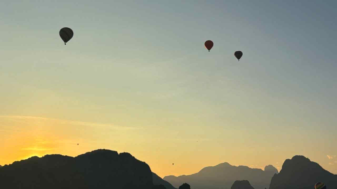 many hot air balloons are flying in the sky at sunset