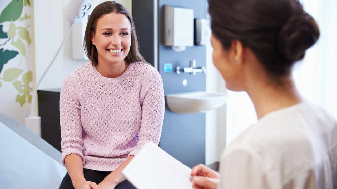 a person is talking to a doctor while sitting in a chair