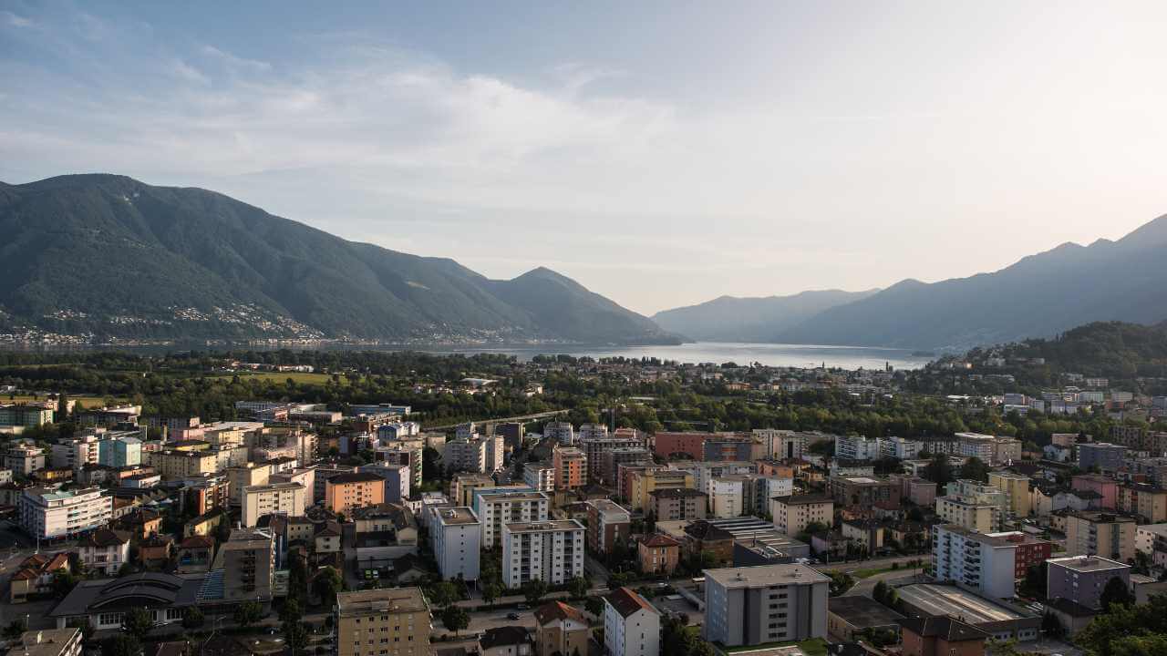an aerial view of a city with mountains in the background