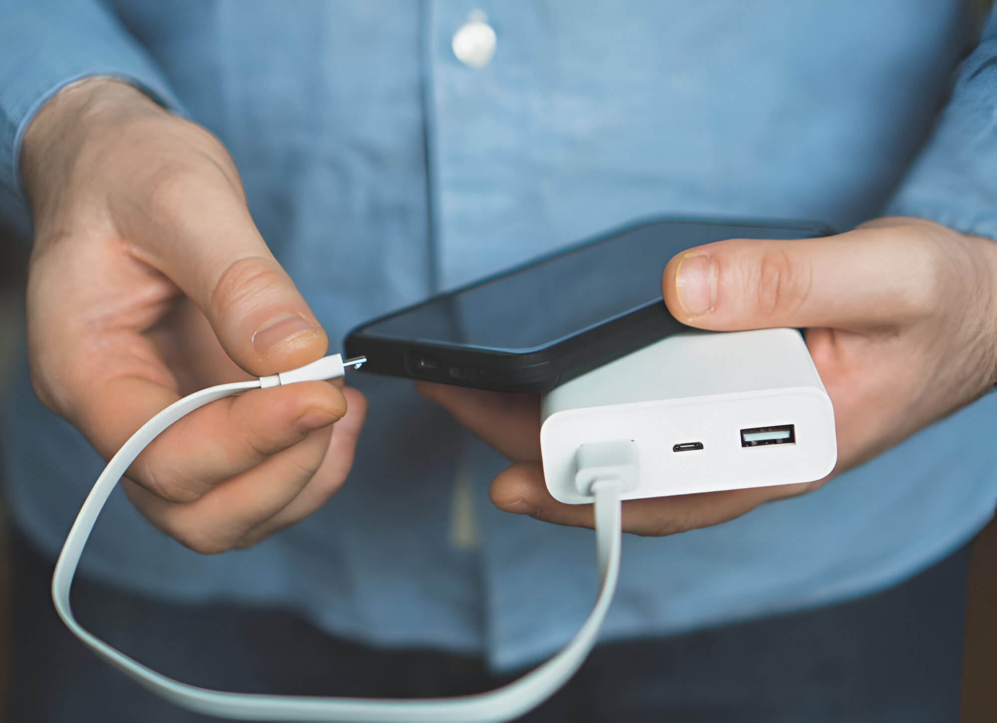 person plugging their phone into a charger