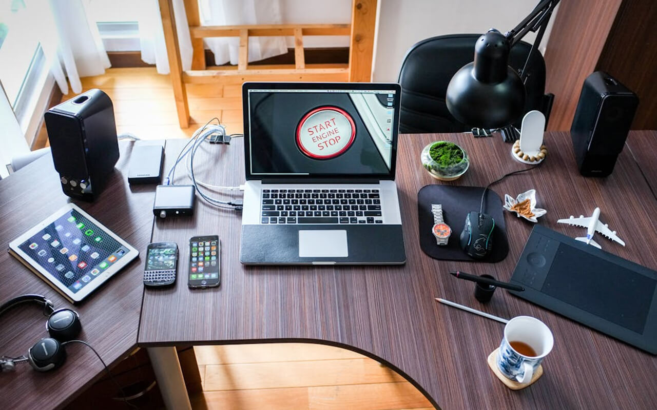 Laptop on desk with other electronics 