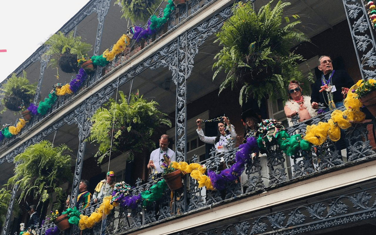 people throwing beads during mardi gras in new orleans