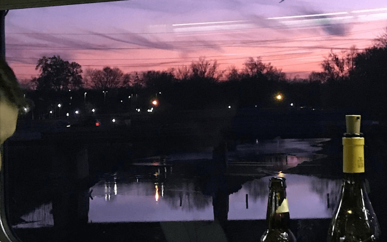 view of a pink and purple sunset from a train window