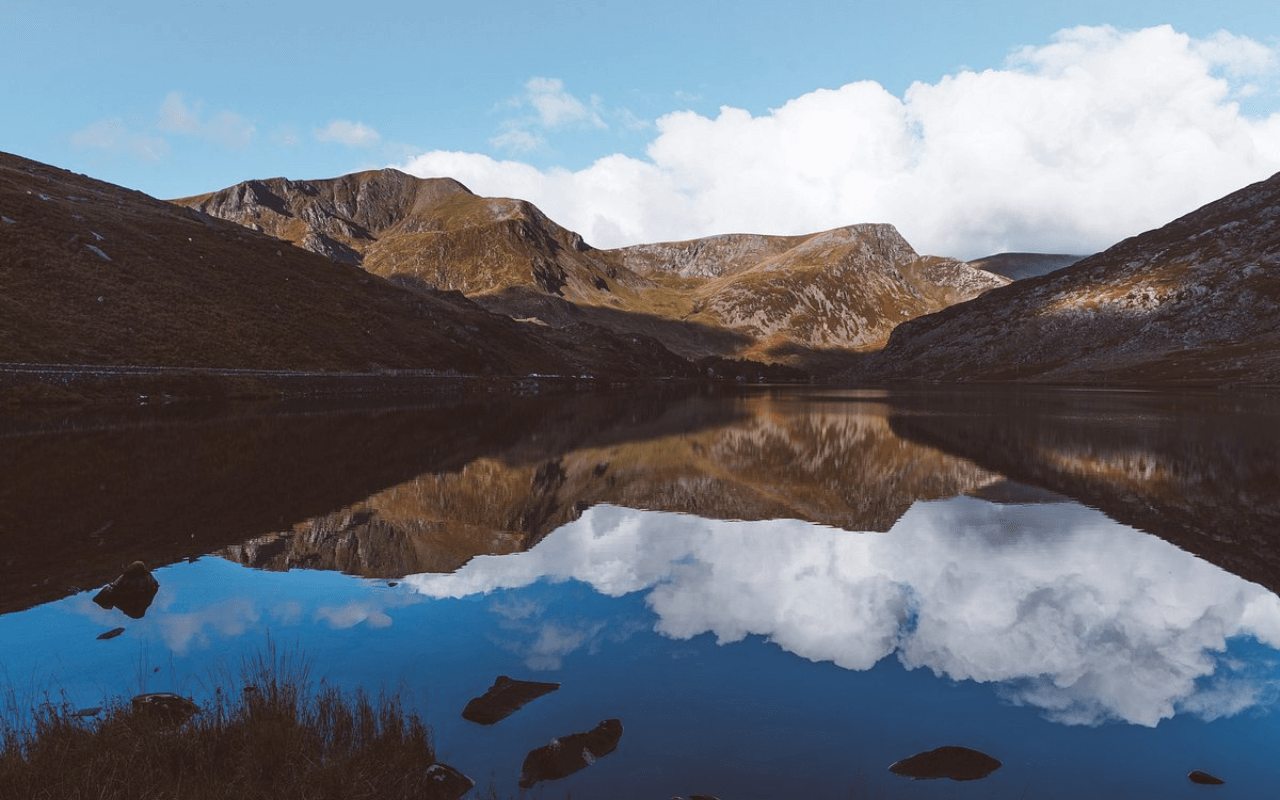mountains reflecting into a body of water
