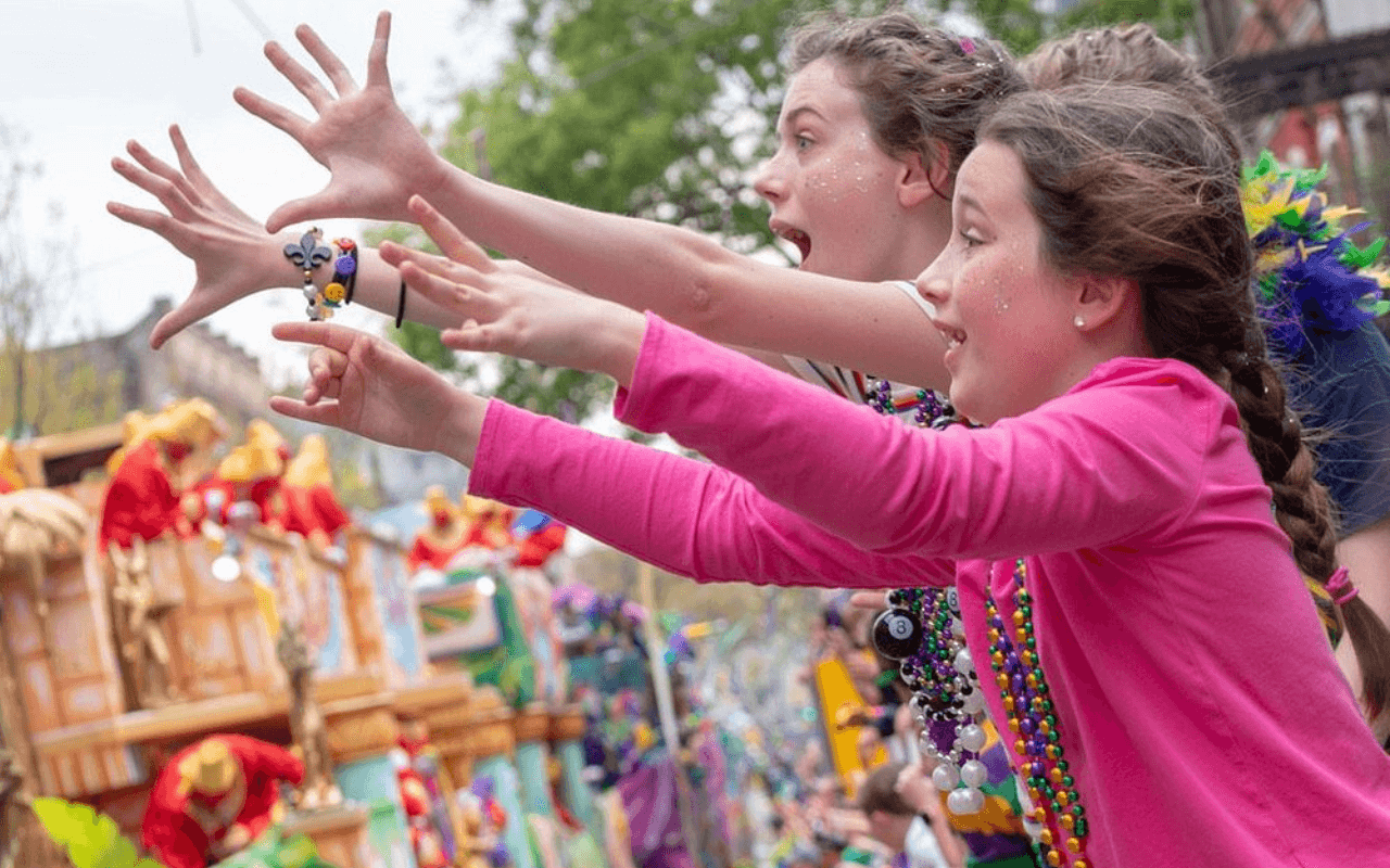kids looking to catch beads during a parade