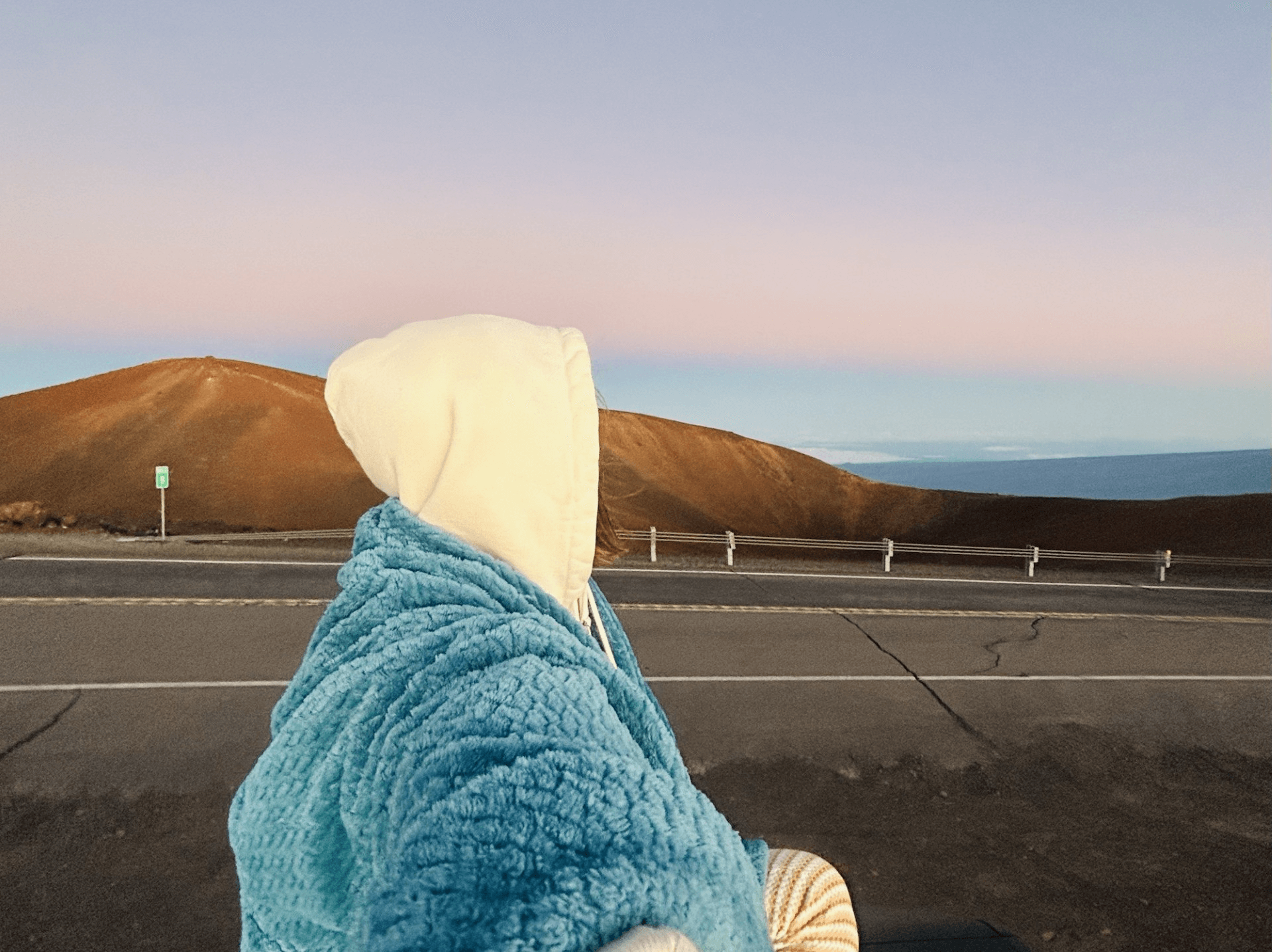 girl walking on the side of the road during sunset