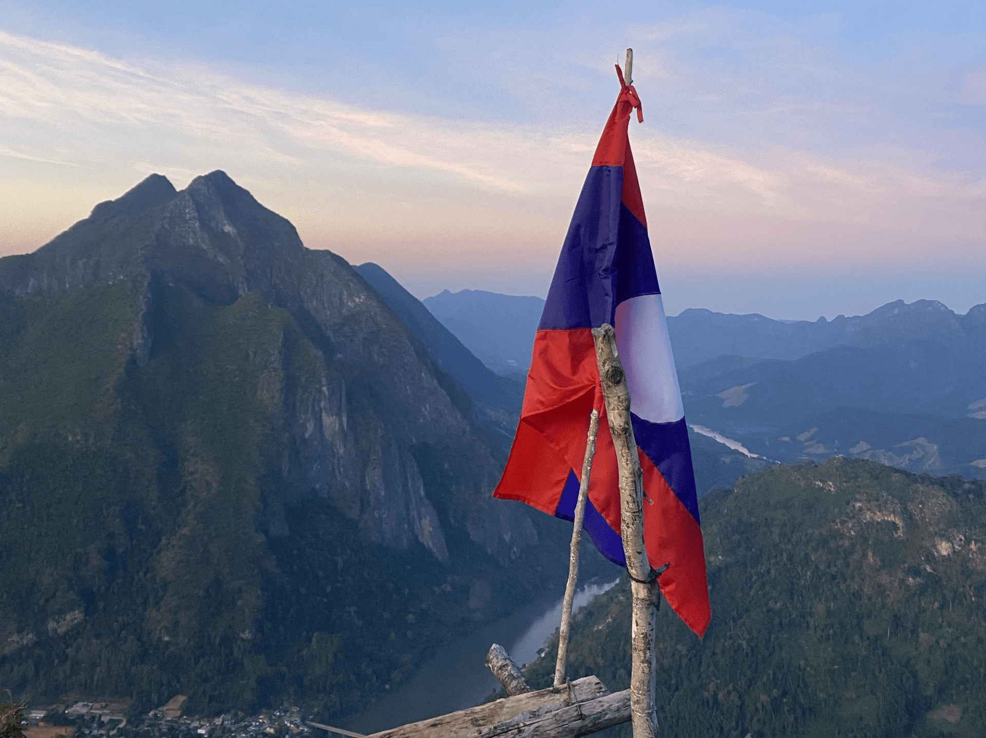 flag on a stick with mountains in the background 