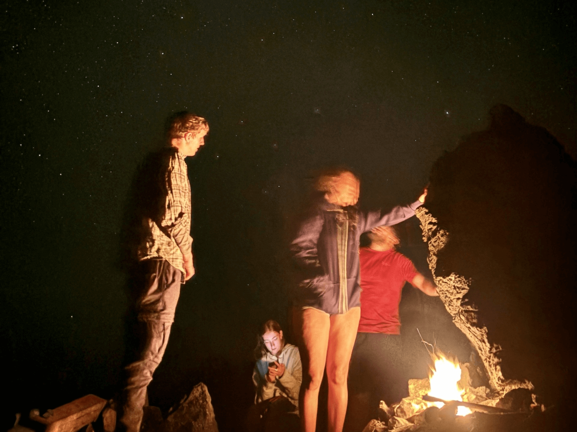 people around a fire at night 