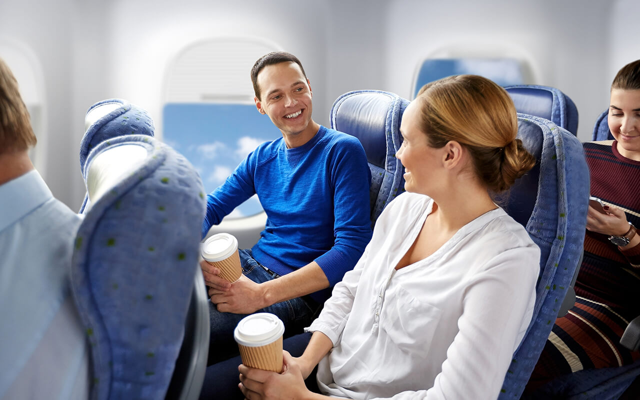 Man and a woman talking on an airplane