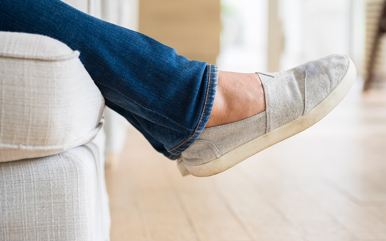 Person wearing shoes while sitting on a couch