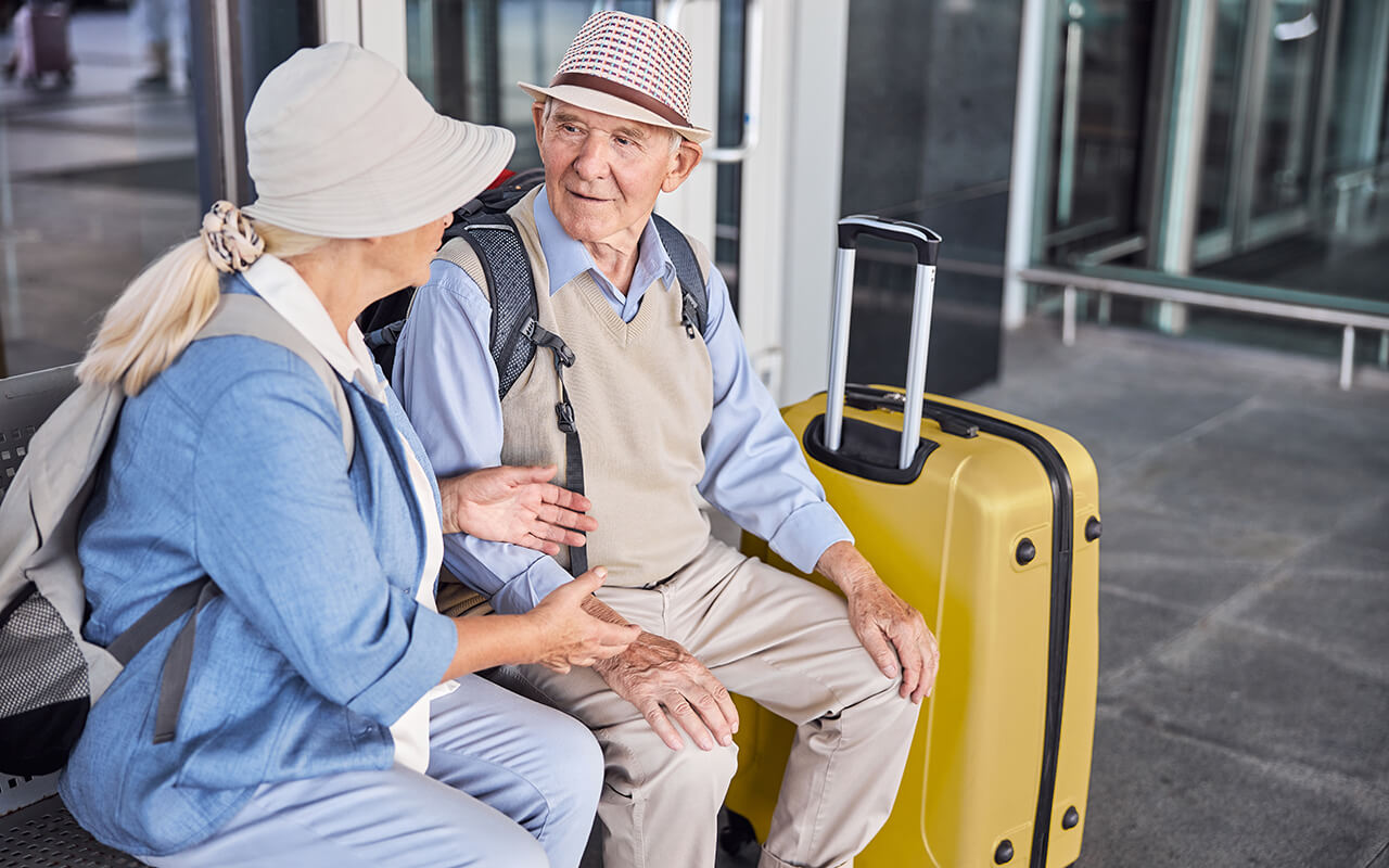Elderly couple at the airport with their luggage