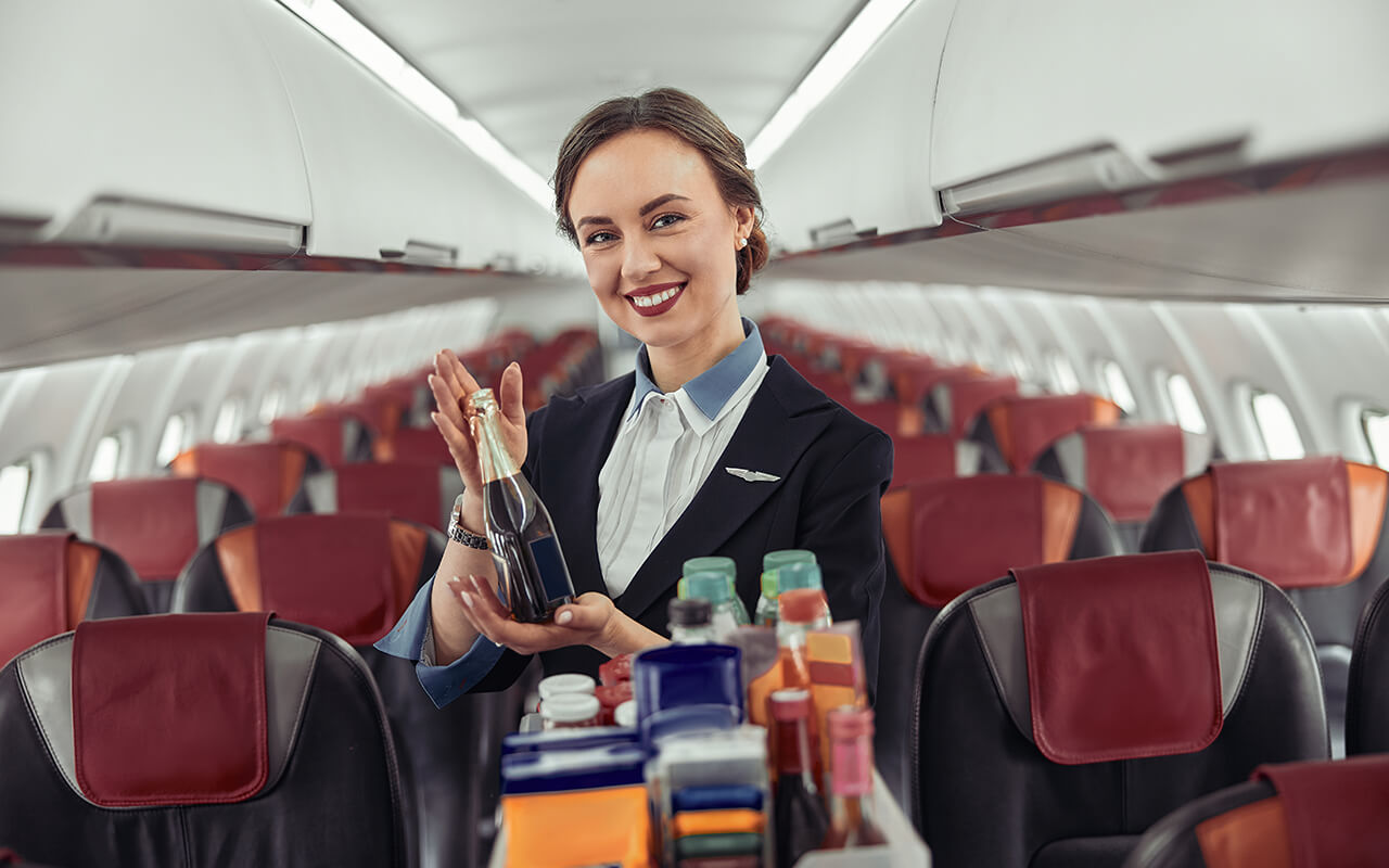 flight attendant serving drinks on an airplane