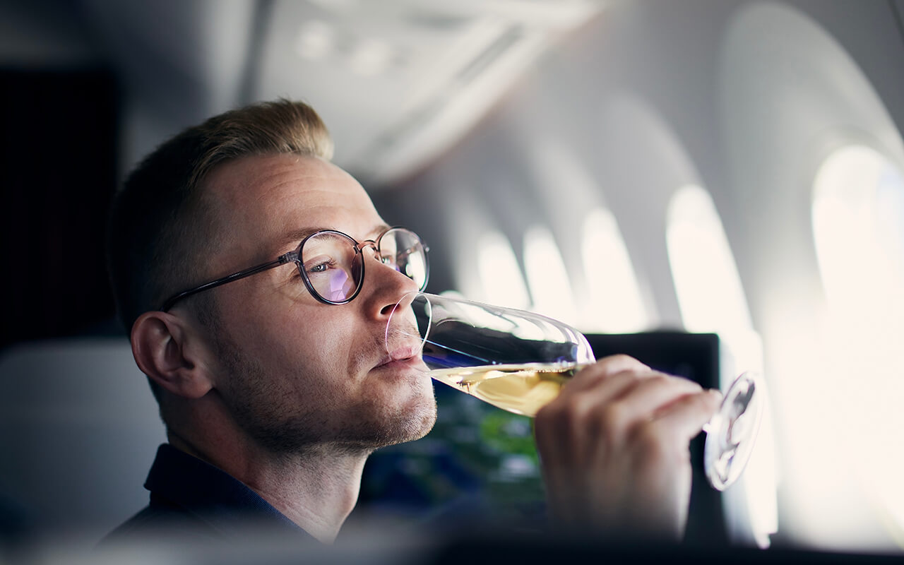 Man drinking alcohol on an airplane