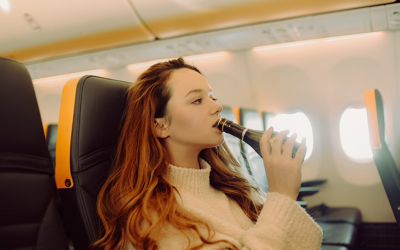 Woman drinking on a plane