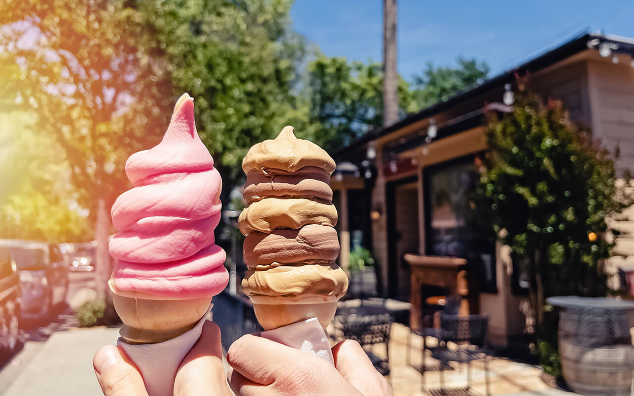 Two people holding ice cream outdoors