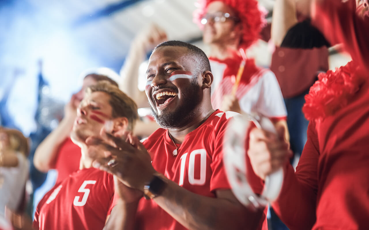 Cheering sports fans in a stadium wearing red jerseys