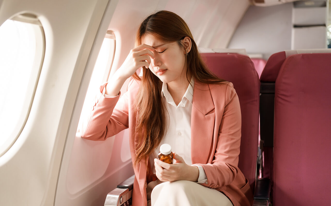 Woman taking medications on airplane