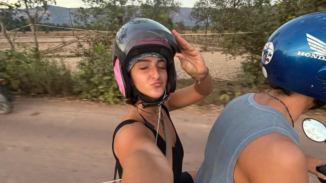 A person and another person on a motorcycle taking a selfie