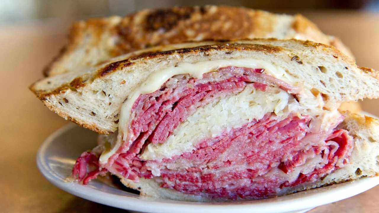 a corned beef sandwich on a white plate