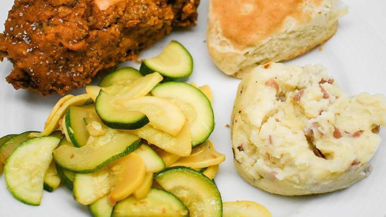 fried chicken, mashed potatoes and zucchini on a white plate