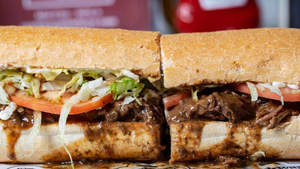 a cut in half sandwich with meat and vegetables