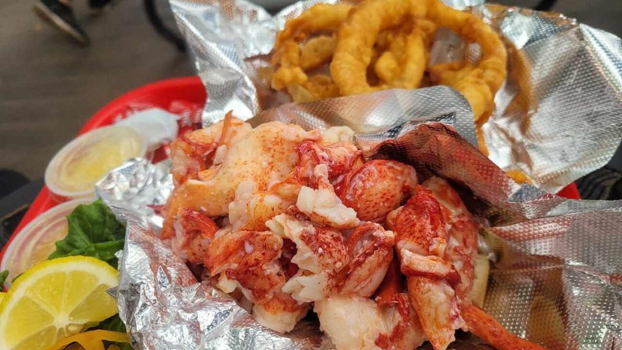 a tray of lobster and onion rings sitting on a table