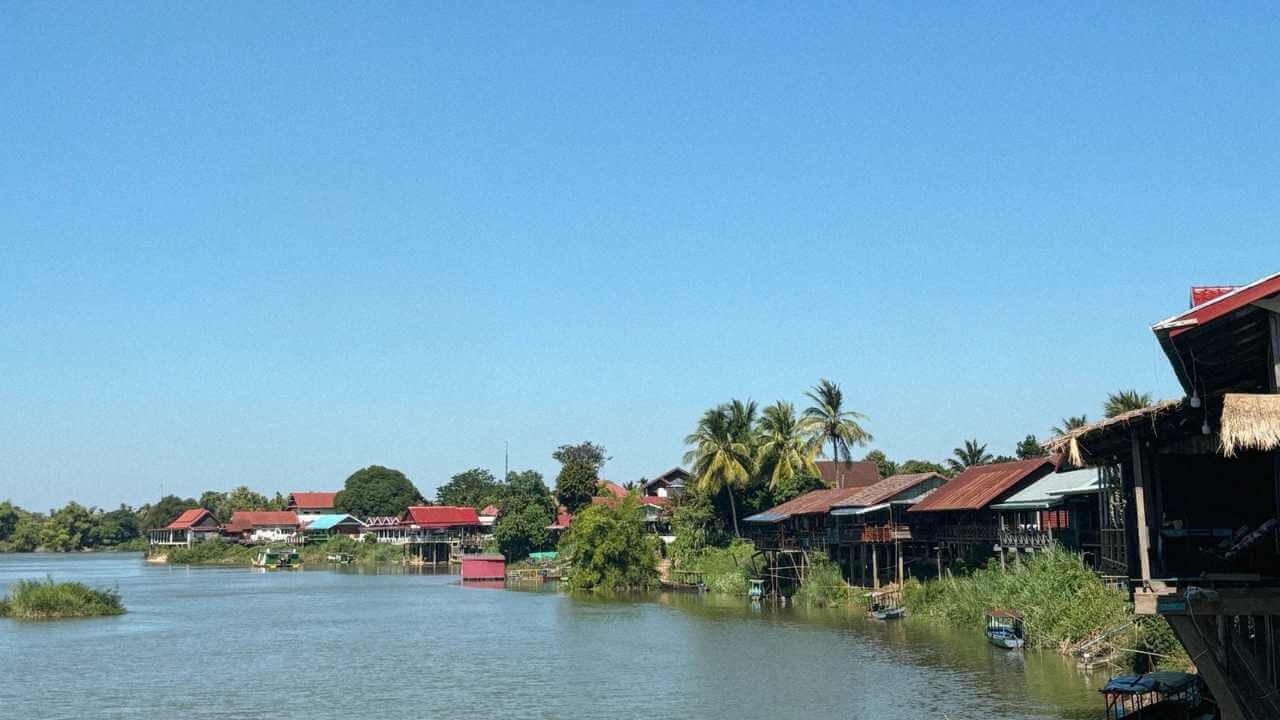 a river with wooden houses on either side of it
