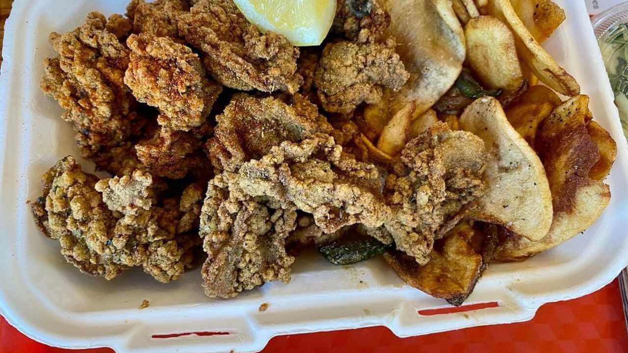 a styrofoam container filled with fried fish and chips