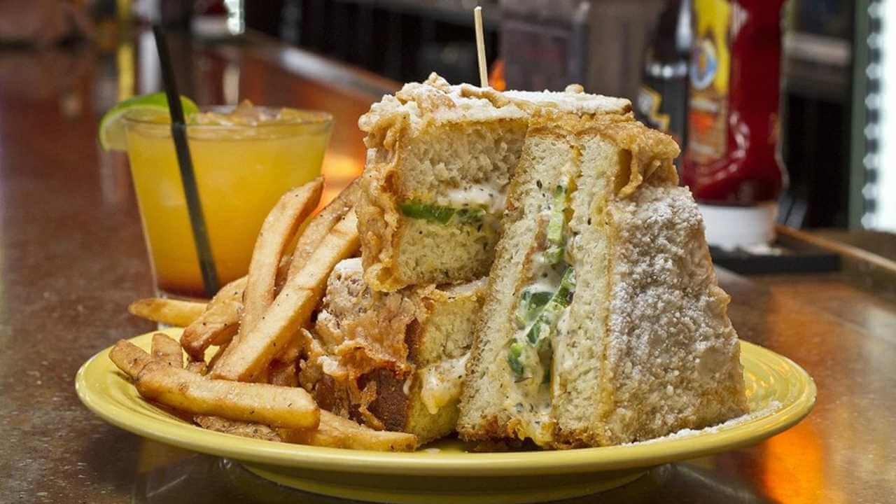 A sandwich and french fries on a yellow plate