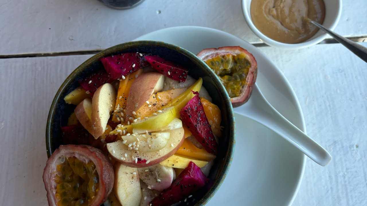 a bowl of fruit and a spoon on a white plate