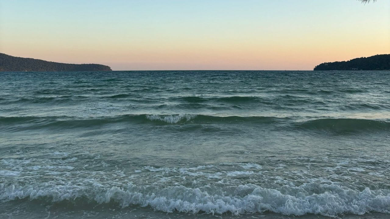 a view of the ocean at sunset from the beach