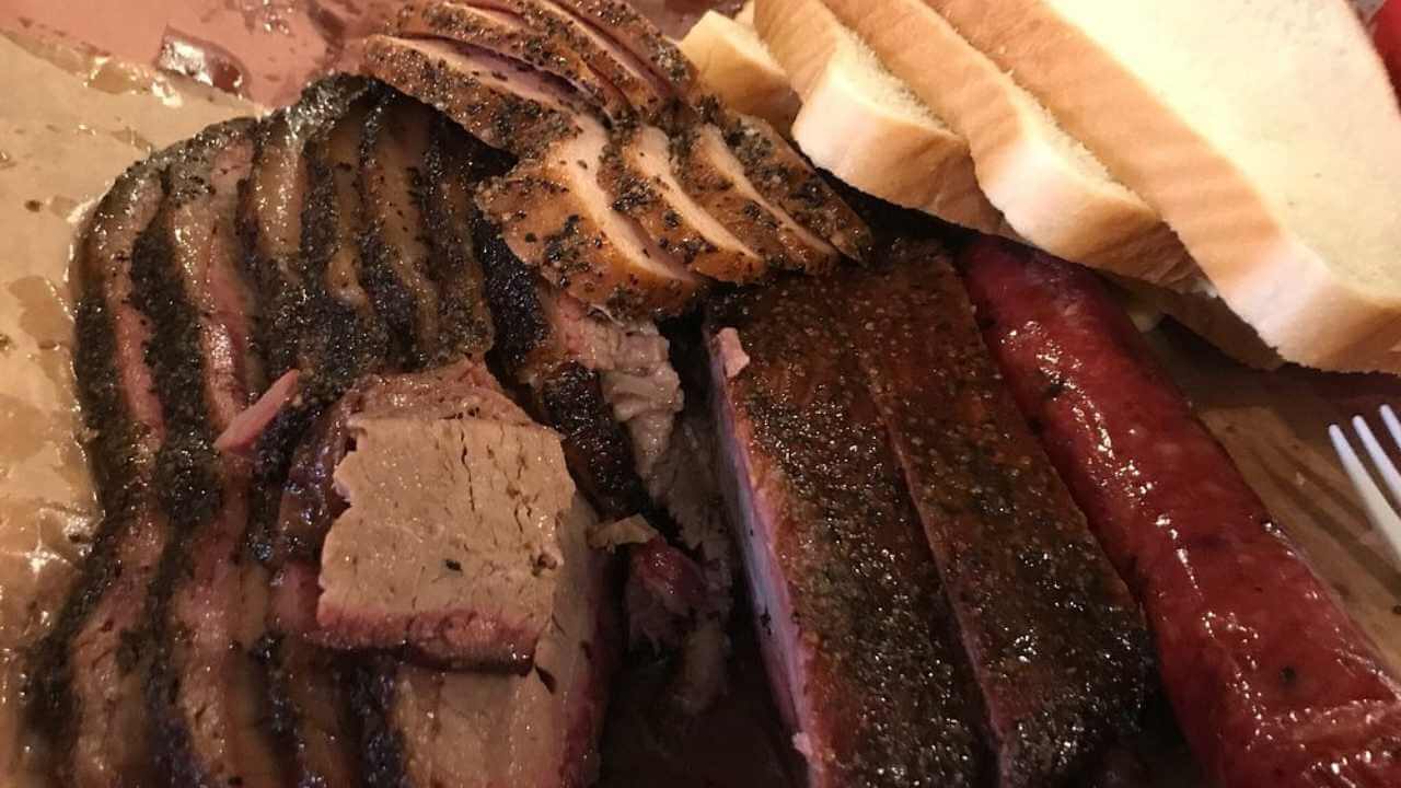 a tray of meat and bread sitting on a table