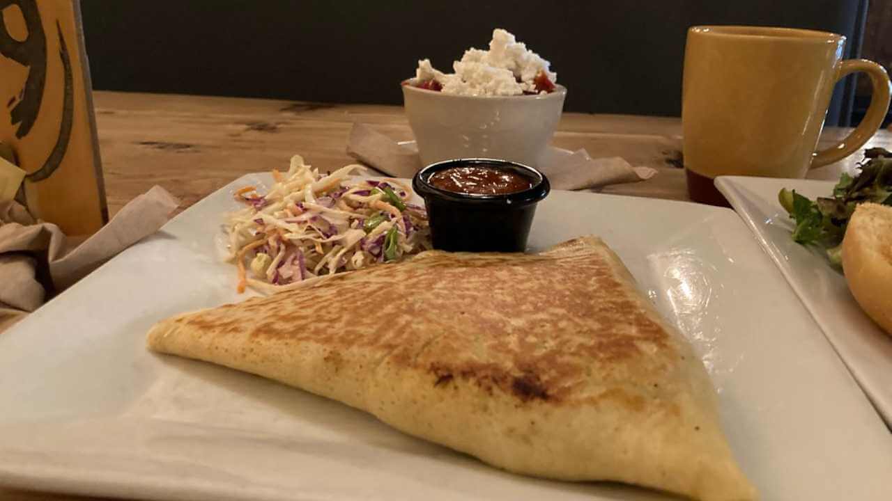 a plate topped with a quesadilla and coleslaw